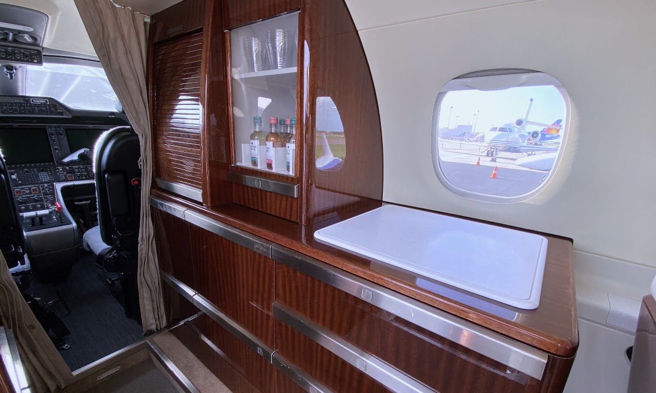 Galley with glassware, bottles and a chilled storage drawer